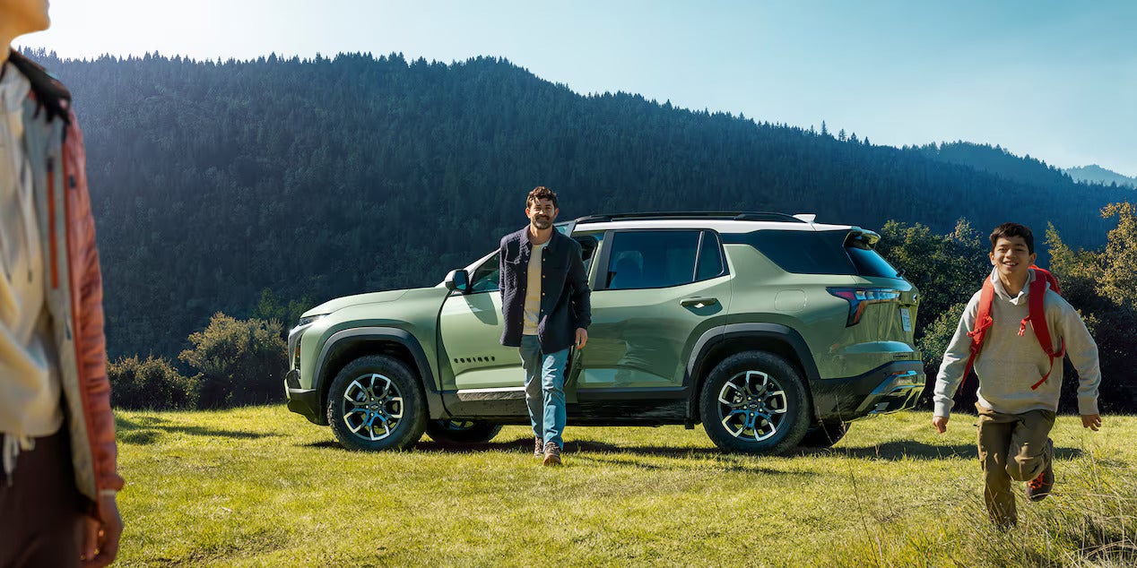 a green suv parked in the woods