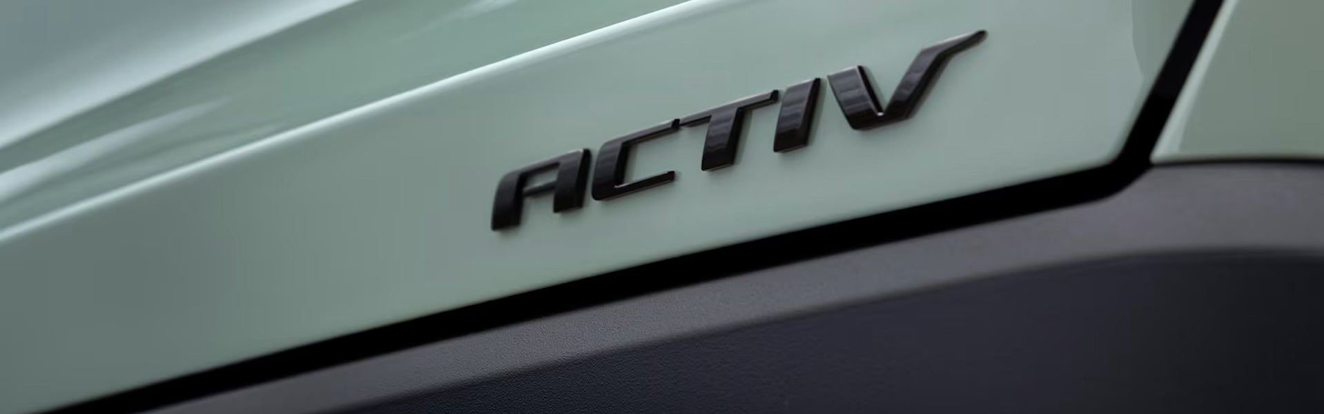 Rear trunk and black badge of a light forest green 2025 Equinox Activ.