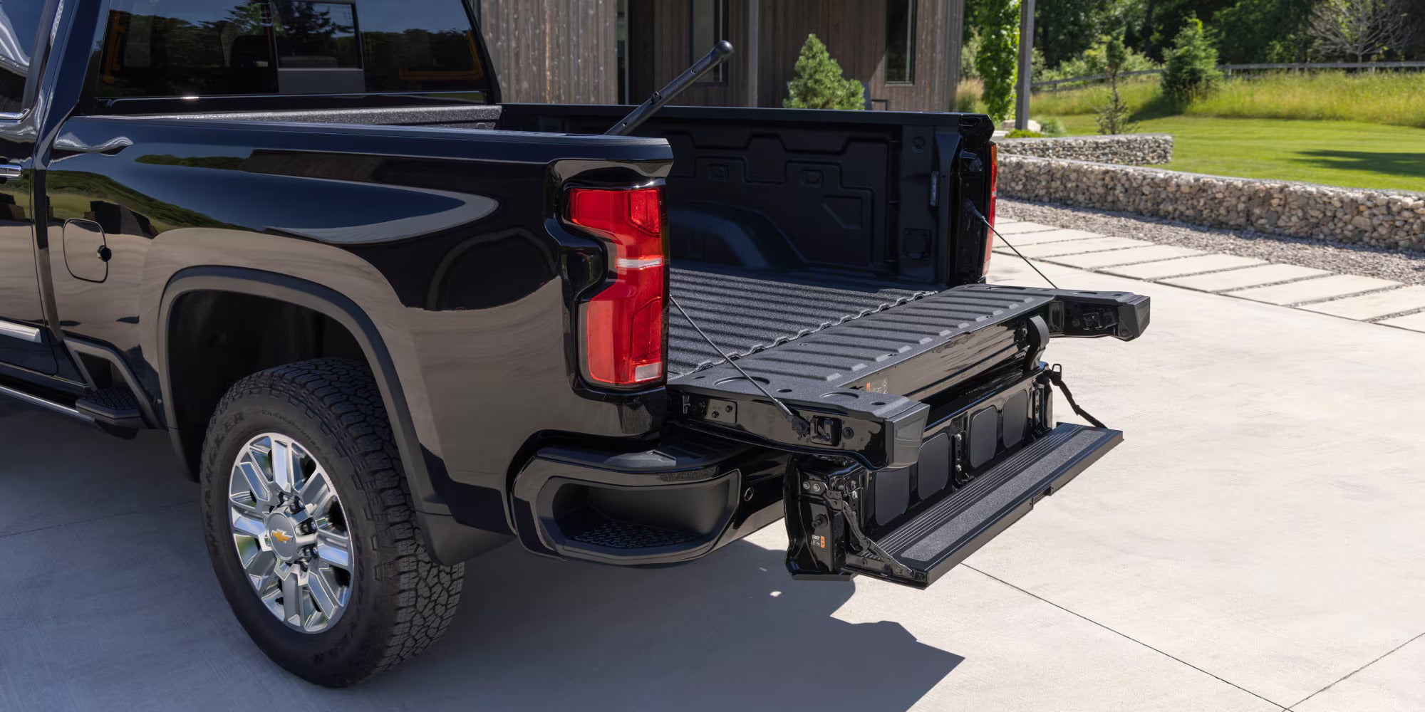 a black 2025 chevrolet silverado hd showing casing the bed and step up on the tailgate