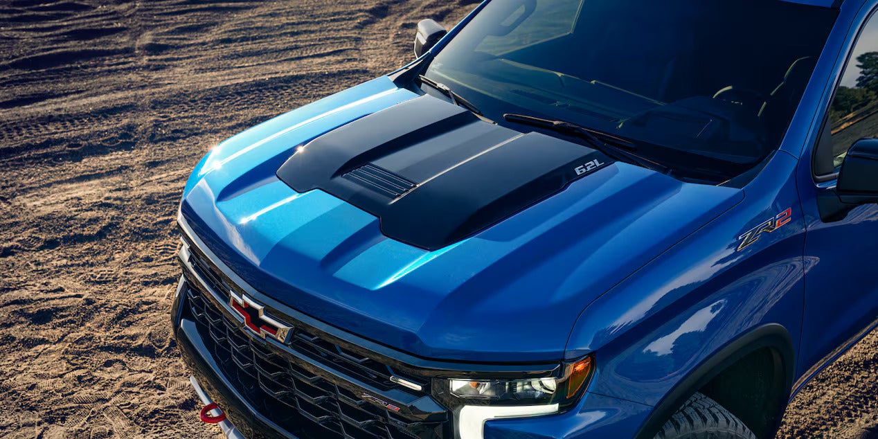 Close-up of the hood and grille of the 2025 Chevrolet Silverado ZR2, featuring bold design elements and the 6.2L engine badge.